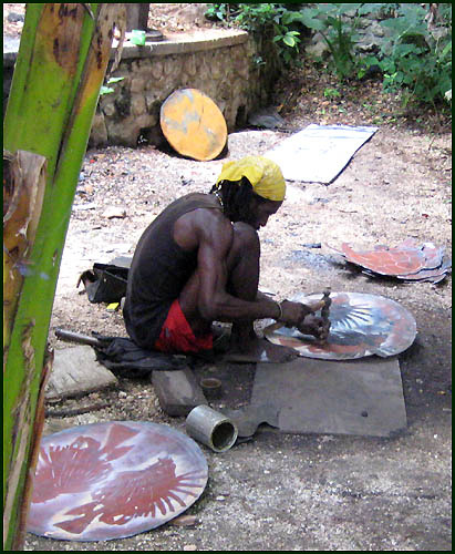 Cutting recycled steel drum in Haiti - Haitian metal tropical designs . - www.tropicdecor.com